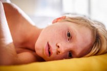 Portrait of a boy in bed waking up — Stock Photo