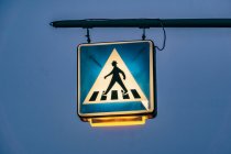 Señal de cruce peatonal iluminada al atardecer, Berlín, Alemania - foto de stock