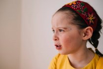 Портрет эмоциональной маленькой девочки на фоне белой стены — стоковое фото
