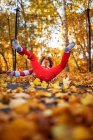 Garçon sautant sur un trampoline couvert de feuilles d'automne, États-Unis — Photo de stock