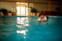 Vater hält seine Tochter im Schwimmbad — Stockfoto