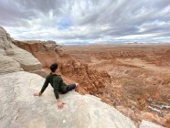 Man sitting on cliff edge, Goblin Valley State Park, Utah, EUA — Fotografia de Stock