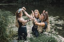 Tres mujeres boho bailando en un lago, Rusia - foto de stock