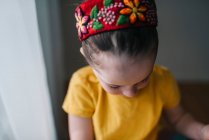 Close-up de uma menina vestindo uma faixa de cabeça no fundo branco — Fotografia de Stock