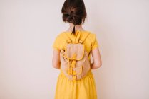 Visão traseira de uma menina usando uma mochila — Fotografia de Stock