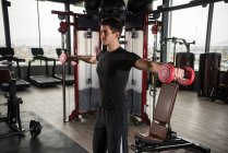 Homme debout dans une salle de gym soulevant des poids — Photo de stock