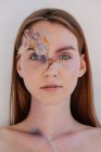 Conceptual beauty portrait of a woman with dried flowers on her face — Stock Photo