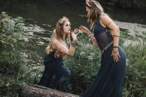 Dos mujeres boho bailando junto a un lago, Rusia - foto de stock