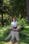 Femme assise sur un tronc d'arbre en train de méditer, Bosnie-Herzégovine — Photo de stock