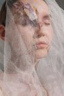 Retrato de belleza conceptual de una mujer con un velo con flores secas en la cara y el cuello - foto de stock