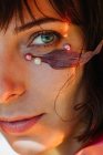 Концептуальный портрет женщины с жемчугом и листом на лице — стоковое фото