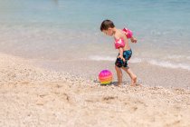Мальчик, пинающий мяч на пляже, Греция — стоковое фото