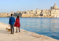 Пара выгуливает свою собаку вдоль набережной, Валлетта, Мальта — стоковое фото