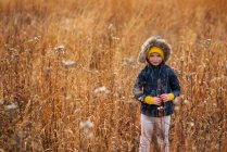 Retrato de una chica sonriente de pie en un campo, Estados Unidos - foto de stock