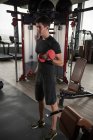 Homme debout dans une salle de gym soulevant des poids — Photo de stock