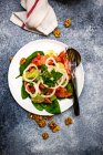 Ensalada de tomate, pepino y cebolla con aderezo de nuez y nueces frescas - foto de stock