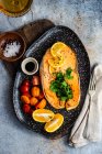 Стейк из лосося на гриле с помидорами, лимоном и бокалом белого вина — стоковое фото