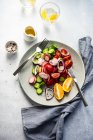 Томатный, огурец, красный лук и салат из редиса со стаканом лимонной воды — стоковое фото