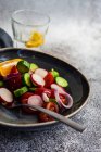 Tomate, pepino, cebola vermelha e salada de rabanete com um copo de água com limão — Fotografia de Stock