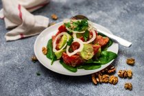 Georgischer Tomaten-, Gurken- und Zwiebelsalat mit Walnussdressing und frischen Walnüssen — Stockfoto