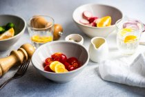 Verre d'eau de citron avec bols de tomate, oignon rouge, radis et concombre — Photo de stock