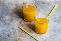 Dois copos de suco de laranja espremido na hora com palhinhas de bebida — Fotografia de Stock