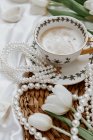 Чашка кави з тюльпанами та ювелірними виробами на столі, близький вигляд, концепція весільного ранку — стокове фото
