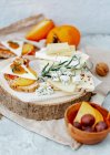 Cheese and nuts on a wooden board — Stock Photo