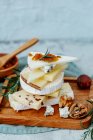 Cheese with figs, grapes and nuts on a wooden background. selective focus. — Stock Photo