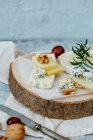 Camembert cheese with figs and nuts on a wooden board — Stock Photo