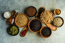 Céréales brutes et variétés de graines dans un bol sur fond de béton — Photo de stock