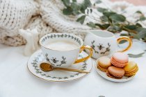 Tasse de café et macarons servis à table — Photo de stock