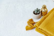 Potted plant and golden pineapple decoration with yellow scarf — Stock Photo