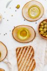 Green olives, olive oil and ciabatta bread. Top view flat lay with copy space — Stock Photo