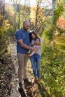Портрет счастливой пары, стоящей в лесу со своей маленькой дочерью, Калифорния, США — стоковое фото