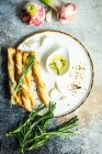 Grissini sticks and olive oil with fresh rosemary served on plate — Stock Photo