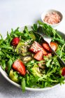 Подается миска со свежей травой и фруктовым салатом на бетонном фоне — стоковое фото