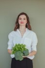 Портрет красивой улыбающейся женщины, держащей свежий брокколи и салат — стоковое фото