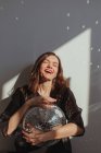 Porträt einer lachenden Frau mit einem Glitzerball — Stockfoto