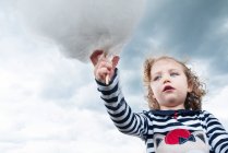 Low angle view of a girl holding candy floss — Stock Photo