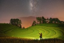 Man standing in terraced rice fields at night below milky way, Mu Cang Chai, Yen Bai, Vietnam — Fotografia de Stock