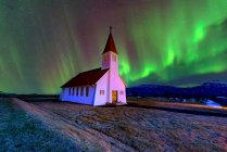 Luces boreales sobre la iglesia de Vikurkirkja, Vik, Islandia - foto de stock
