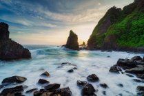 Beach scene with rocks at sunset, West Lombok, Indonesia — Stock Photo