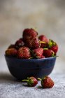Bol de fraises fraîches sur la surface du béton — Photo de stock