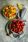 Top view of bowls of red and yellow cherries with cloth napkin — Stock Photo
