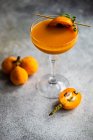 Bicchiere di succo di frutta loquat con pezzo di loquat e timo su bastone — Foto stock
