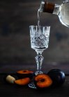 Сливовая водка в холодных стаканах и свежие сливы на столе — стоковое фото