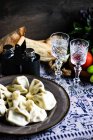 Supra georgiano tradicional com khinkali, conjunto de vegetais e chacha beber em copos — Fotografia de Stock