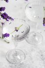 Óculos de gim de limão tônico e flores de lavanda em uma mesa — Fotografia de Stock