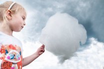 Retrato de uma menina segurando fio dental de doces que se parece com uma nuvem, Polônia — Fotografia de Stock